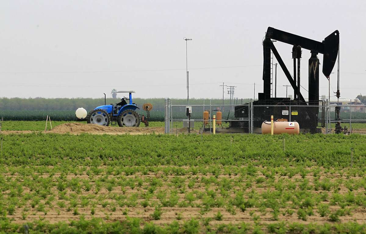 A tractor shares farmland with an oil pump in a field on March 5, 2014, near Shafter, Calif. Though there could be 15 billion barrels of oil trapped in the Monterey Shale in Kern County, getting to them through California's complicated, earthquake-altered geology could be a prohibitively expensive undertaking. (Brian van der Brug/Los Angeles Times/MCT)