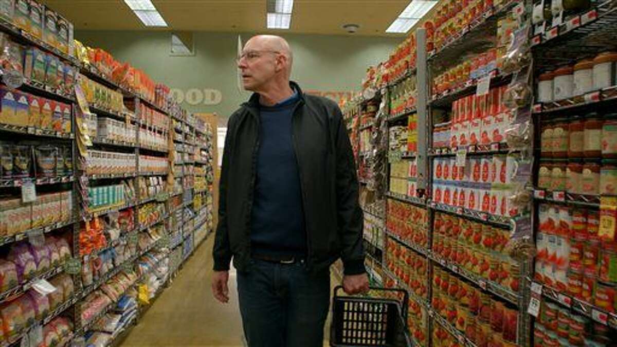 In this undated photo provided by Kikim Media, author and host Michael Pollan educates viewers how to shop the outer perimeter of the supermarket to find real food rather than “food-like substances," in a scene from the documentary film, “In Defense of Food." (John Chater/Kikim Media via AP)
