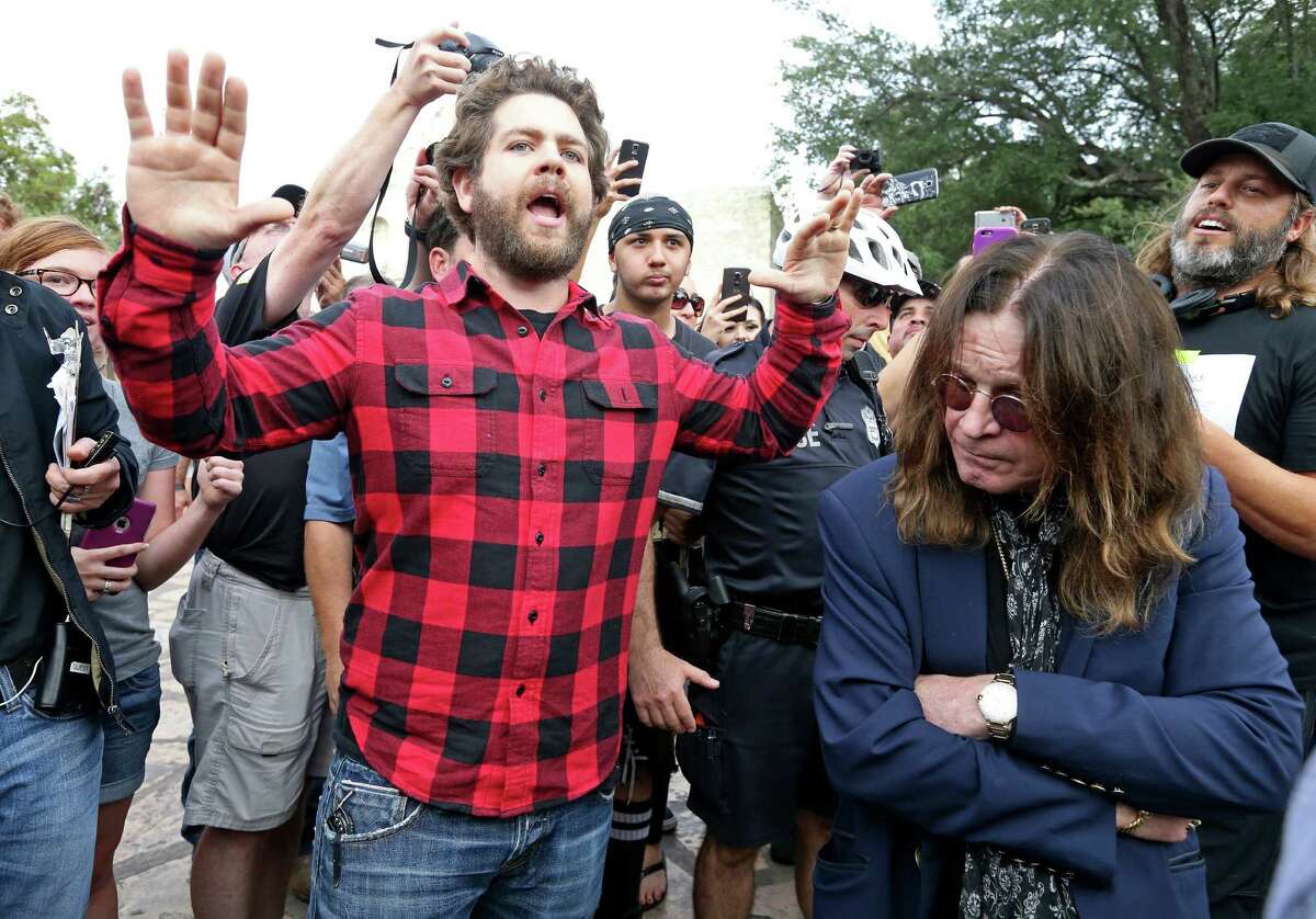 Jack Osbourne (center) tries to calm the crowd as he and his father Ozzy Osbourne (right) arrive at the Alamo to tape scenes for an episode of “Ozzy & Jack's World Detour.”