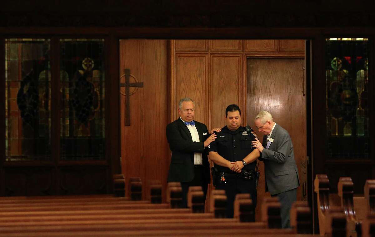 Tripp Stuart, left, and Ken Finch pray for San Antonio Police Detective George Silva during a Citywide Prayer Service for First Responders and Unity at First Presbyterian Church, Wednesday, July 20, 2016. Members from different churches offered their prayers for the law enforcement community and the City of San Antonio.
