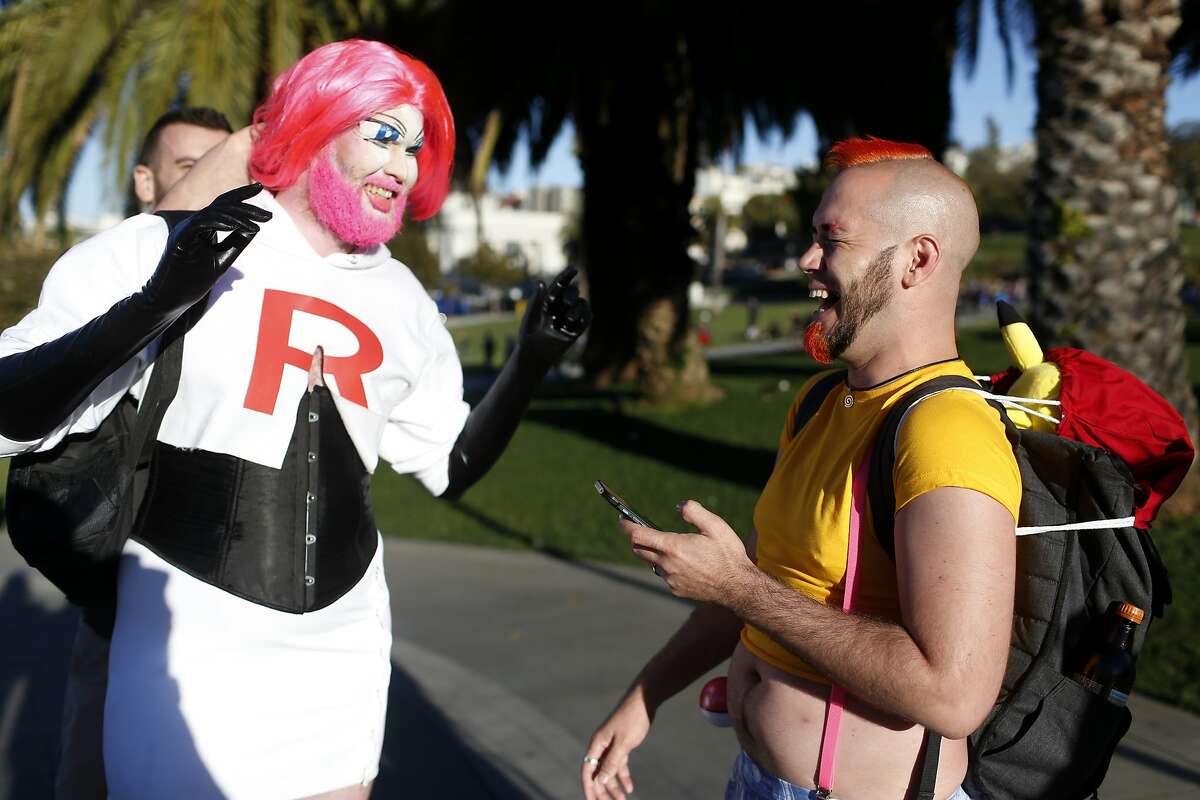 Mike Evans (left) of San Francisco, is dressed as the Pokemon character Jesse while Sirius Spirit (right) plays Pokemon Go at Dolores Park on Wednesday, July 20, 2016 in San Francisco, Calif.