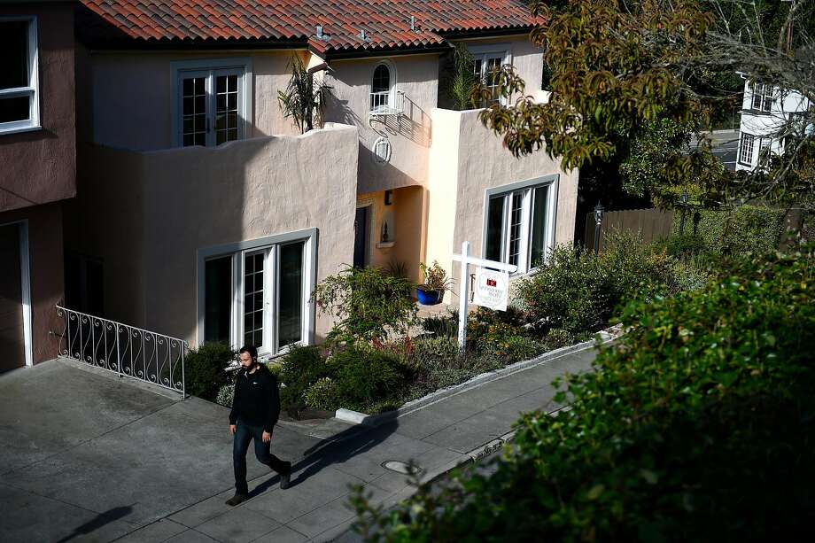 A passerby walks by a home for sale in San Francisco. Only 15 percent of households in the city can afford a median-price home, which averages $1,610,000, according to a new survey. Photo: Michael Noble Jr. / The Chronicle 2016
