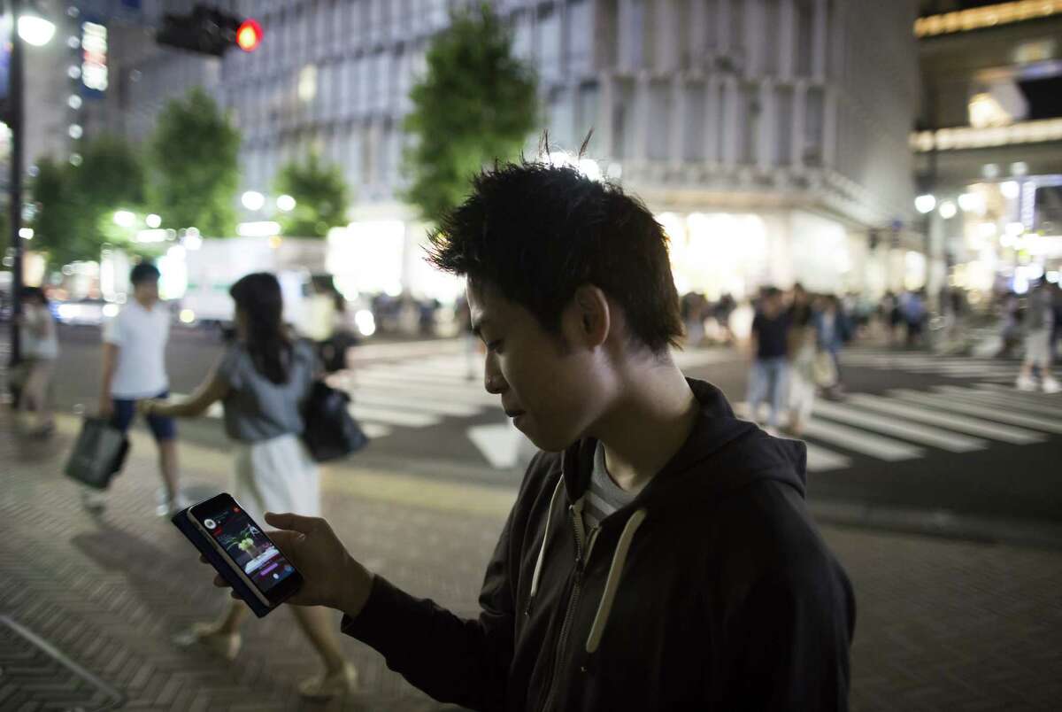 A "Pokémon Go" player concentrates Friday in Tokyo. Japan's National Center of Incident Readiness and Strategy for Cybersecurity has issued public safety tips for players. ﻿