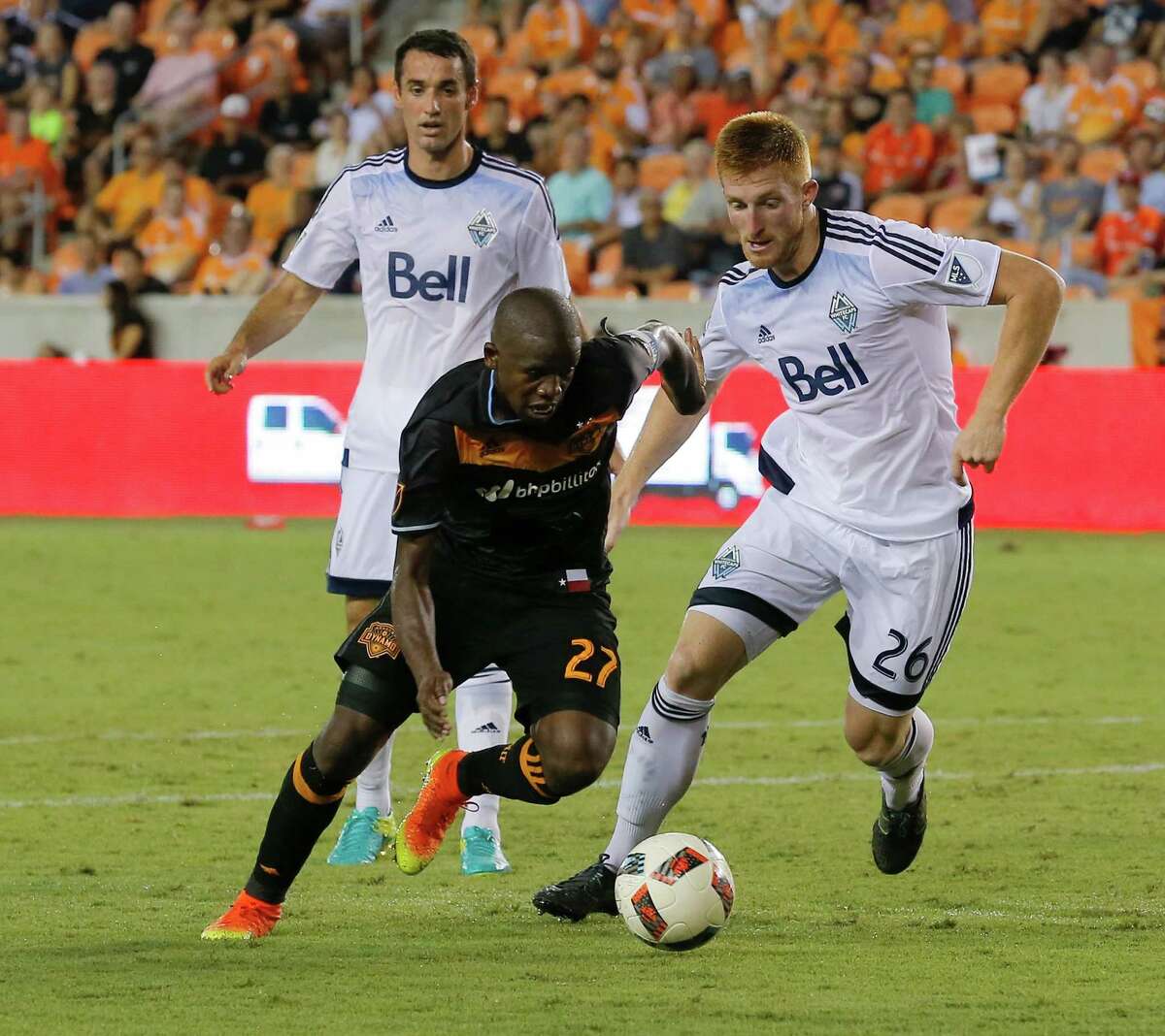 Houston Dynamo midfielder Oscar Garcia (27) dribbles around Vancouver Whitecaps defender Tim Parker (26) during the second half during an MLS soccer match Saturday, July 23, 2016, in Houston. Houston and Vancouver played to scoreless draw. (AP Photo/Bob Levey)