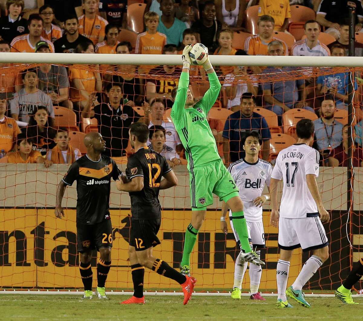 Houston Dynamo goalkeeper Joe Willis (31) makes save as Vancouver Whitecaps midfielder Andrew Jacobson (17) watches the second half during an MLS soccer match Saturday, July 23, 2016, in Houston. Houston and Vancouver played to scoreless draw. (AP Photo/Bob Levey)