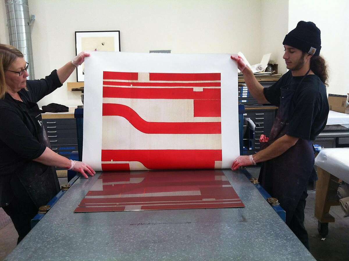 Pam Paulson and Alexander Groshong pulling a print by Caio Fonseca at Paulson Bott Press in Berkeley.