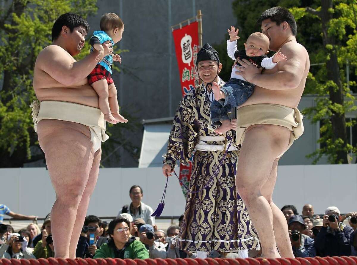 TOKYO - APRIL 25: Sumo wrestling students hold babies as they try to make them cry during the Crying Sumo competition at Sensoji Temple on April 25, 2010 in Tokyo, Japan. The first baby to cry wins the competition. The ceremony takes place in Japan to wish for the good health of the child as it is said that crying is good for the health of babies. (Photo by Koichi Kamoshida/Getty Images)