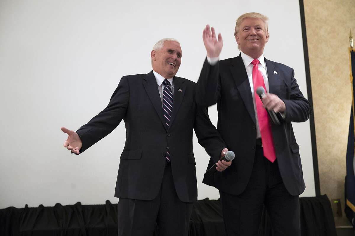 Republican presidential candidate Donald Trump, right, is introduced by vice presidential candidate Gov. Mike Pence, R-Ind., in an overflow room at a town hall, Monday, July 25, 2016, in Roanoke, Va. (AP Photo/Evan Vucci)