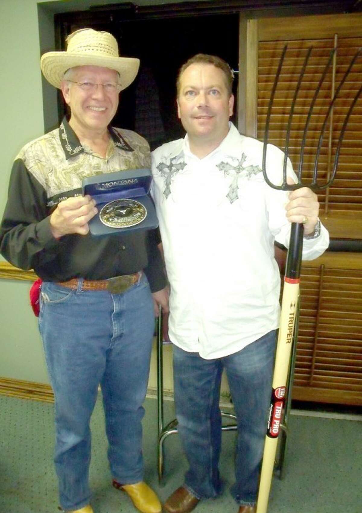 In this 2010 file photo, Charles “Salty Dog” Starnes (left), representing Pakmail Co. of Plainview, shows off the belt buckle he received for winning the Trail Boss Shoot Out Contest and a place at the head of this Saturday’s Cowboy Days Parade. Beside him is Anthony Brocato, from PNS/UMC Family Medical Care, with his “Trail Hand” pitchfork. As last-place finisher, Brocato will bring up the rear of the cattle drive and parade.