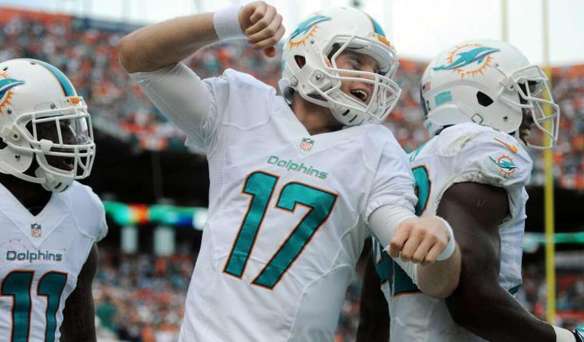 Miami Dolphins quarterback Ryan Tannehill celebrates a touchdown to Mike Wallace in the second quarter against the New England Patriots Sunday. The product of Big Spring High School is growing into a franchise quarterback for the Dolphins and is fueling their run toward the playoffs.