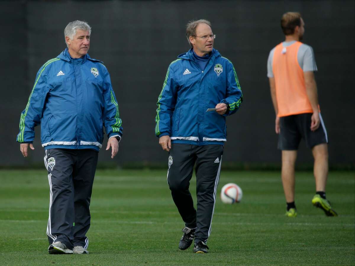 Seattle Sounders head coach Sigi Schmid, left, watches player drills with assistant coach Brian Schmetzer, center, during an MLS soccer training session, Tuesday, Oct. 27, 2015, in Tukwila, Wash.(AP Photo/Ted S. Warren)