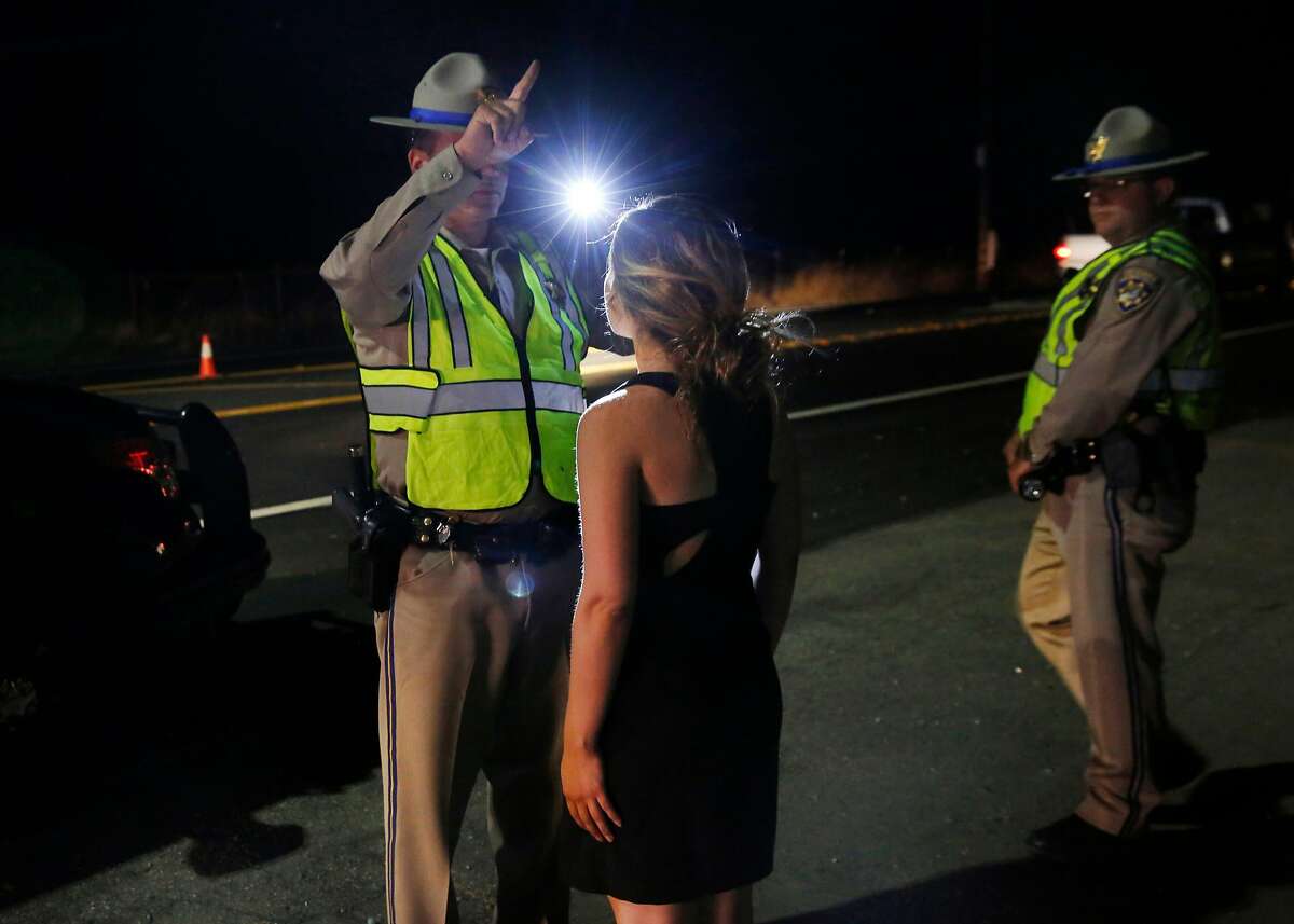 Officer B. Calero gives a specific sobriety test to a young woman suspected to be under the influence of marijuana at a California Highway Patrol driver license and sobriety checkpoint July 22, 2016 in Livermore, Calif.