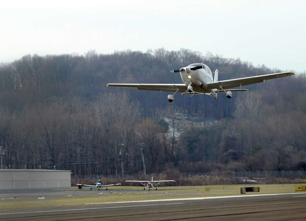 A plane takes off from Danbury Airport Friday, January 15, 2016. Backyard trees have grown so tall at the western approach of a Danbury Airport runway that the FAA has ordered the trees cut down at a cost of nearly $1 million, most of which will be paid for by the federal government. The money will be used to buy easements at a half dozen homes at the Ridgefield border where the trees will be removed.
