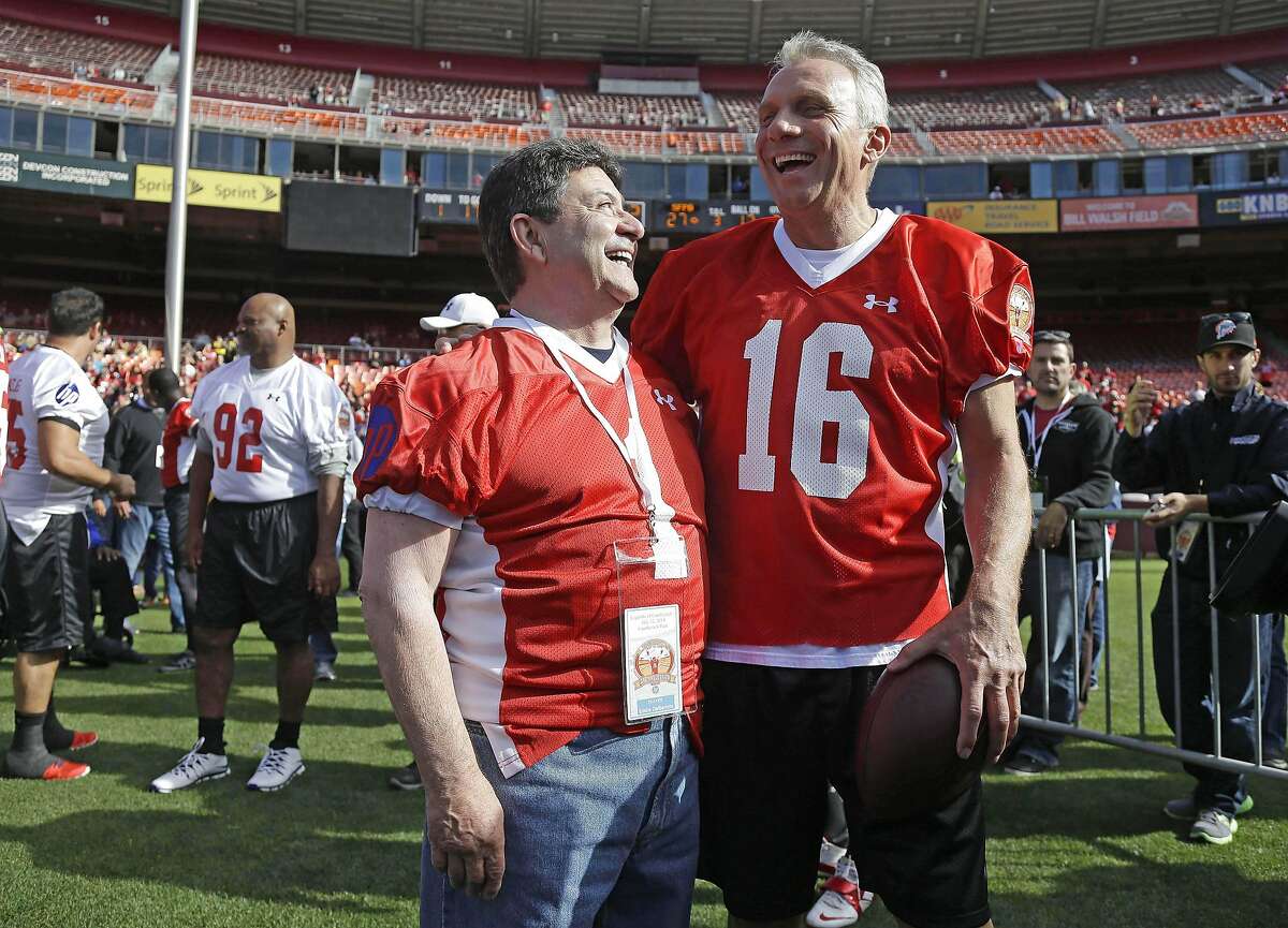 FILE - In this July 12, 2014, file photo, San Francisco 49ers Hall of Fame quarterback Joe Montana, right, laughs with former team owner Edward DeBartolo Jr., left, before the "Legends of Candlestick" flag football game in San Francisco. DeBartolo played no favorites. When it came to the way he treated his employees, from the biggest stars on the field to the office workers way behind the scenes, his care was real. It still is. "Mr. D" always did business his way, and that meant never separating himself from anyone tasked with keeping his successful franchise running and winning each day, and on Saturday he could become a Hall of Famer at long last. (AP Photo/Eric Risberg, File)