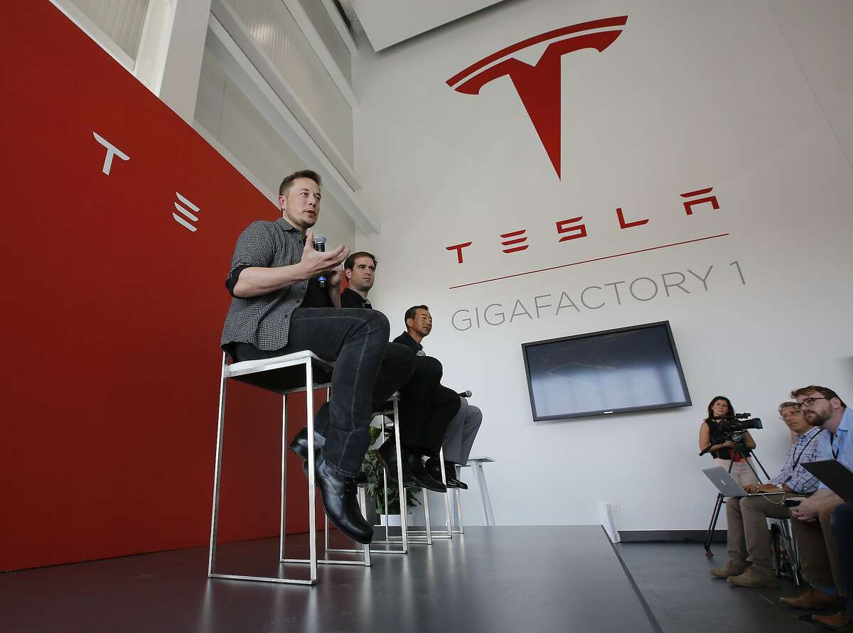 Elon Musk, CEO of Tesla Motors Inc., left, discusses the company's new Gigafactory Tuesday, July 26, 2016, in Sparks, Nev. It's Tesla Motors biggest bet yet: a massive, $5 billion factory in the Nevada desert that could almost double the world's production of lithium-ion batteries by 2018. In the center is J.B. Straubel, Tesla's chief technical officer and at right is Yoshihiko Yamada, executive vice president of Panasonic. (AP Photo/Rich Pedroncelli)