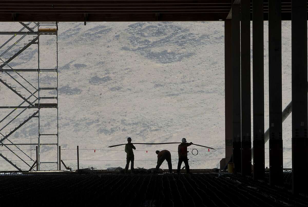 Construction workers are seen in the through uncompleted D section of new Tesla Motors Inc., Gigafactory, Tuesday, July 26, 2016, in Sparks, Nev. It's Tesla Motors biggest bet yet: a massive, $5 billion factory in the Nevada desert that could almost double the world's production of lithium-ion batteries by 2018. (AP Photo/Rich Pedroncelli)