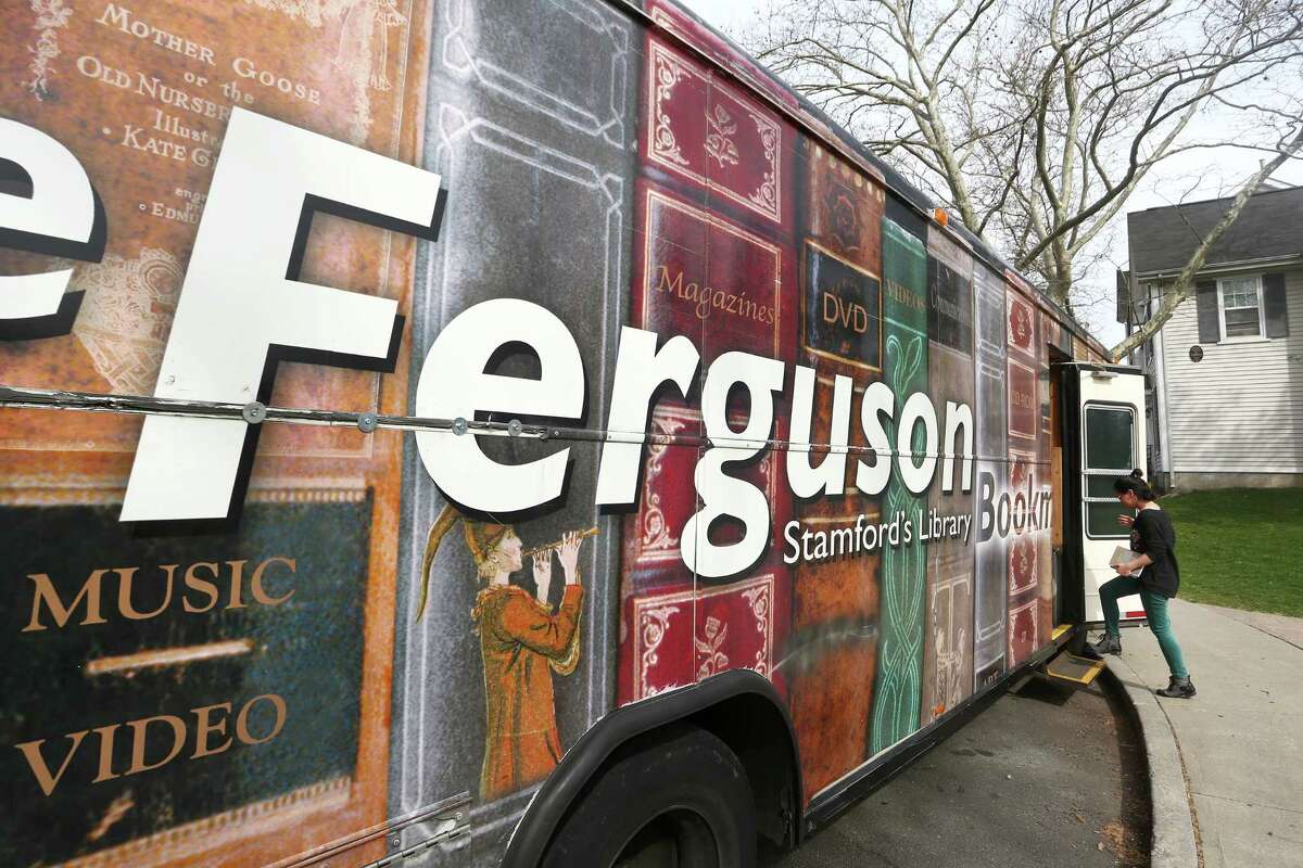 Ferguson Library employee Ashley Hamel boards the Ferguson Library Bookmobile during a stop at the Chester Addison Community Center on Thursday, March 31, 2016.