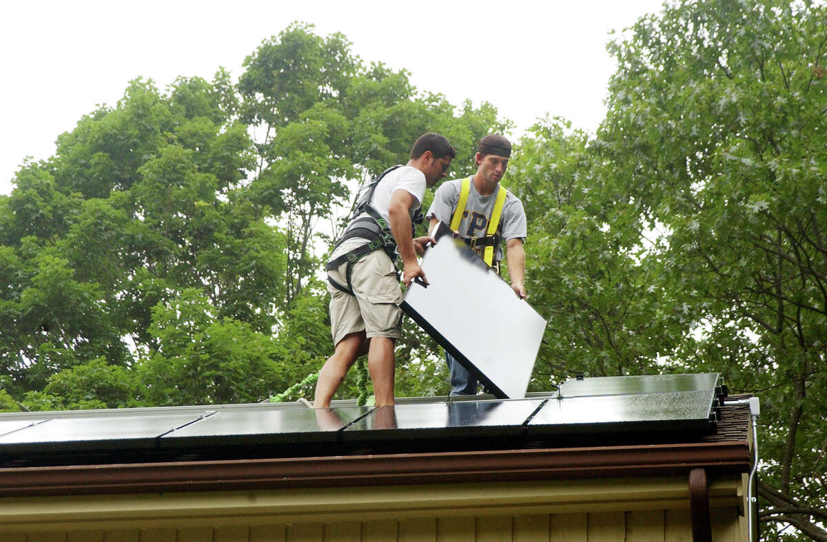 Josh Carter and Ryan Bigham of Solar Works install solar panels on roof in Wilton.
