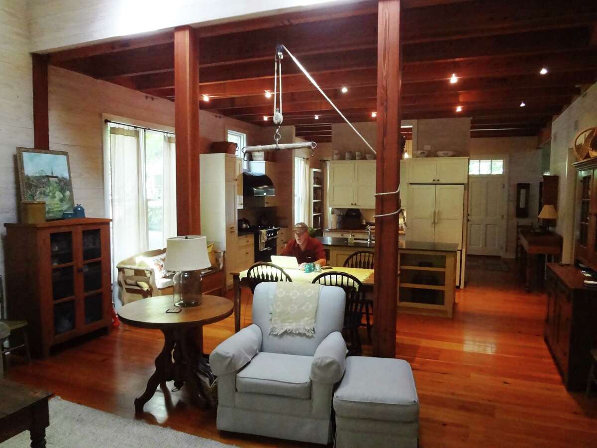 Exposed wood beams and longleaf pine floors warm up the downstairs rooms of Mickey Conrad's home.
