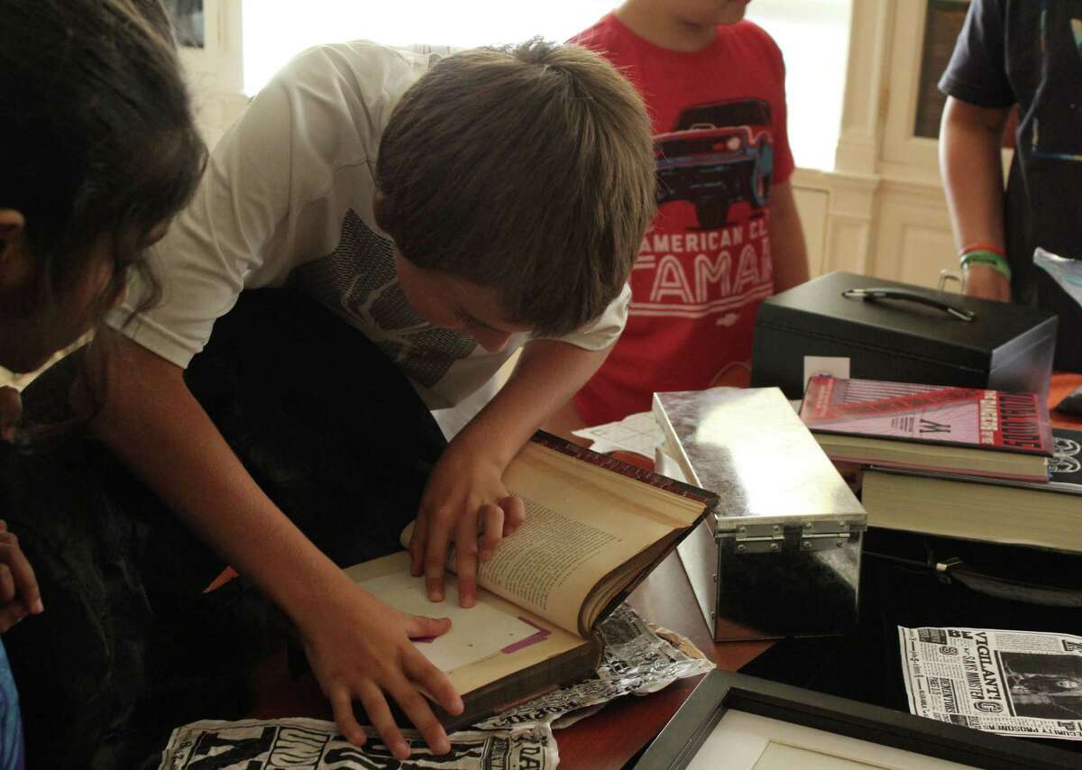 Jonathan Swan deciphers a coded clue during the Harry Potter-themed locked room mystery session for tweens at the public library on July 27, 2016 in Fairfield, Conn. The event is also including sessions for teens and adults.