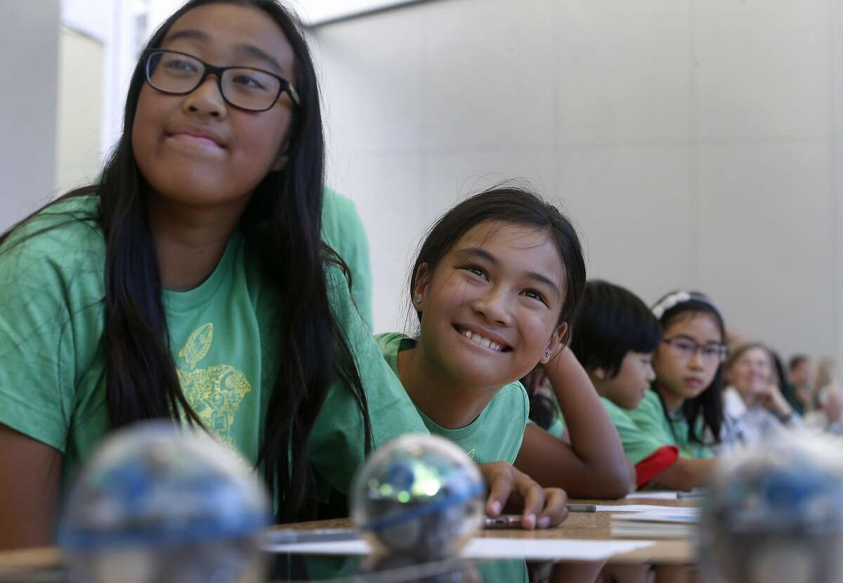 Audrey Thiphadong (left), 12, and Trinity Nguyen, 10, learn how to program and control a Sphero robotic ball at an Apple youth coding class in San Francisco, Calif. on Thursday, July 28, 2016.