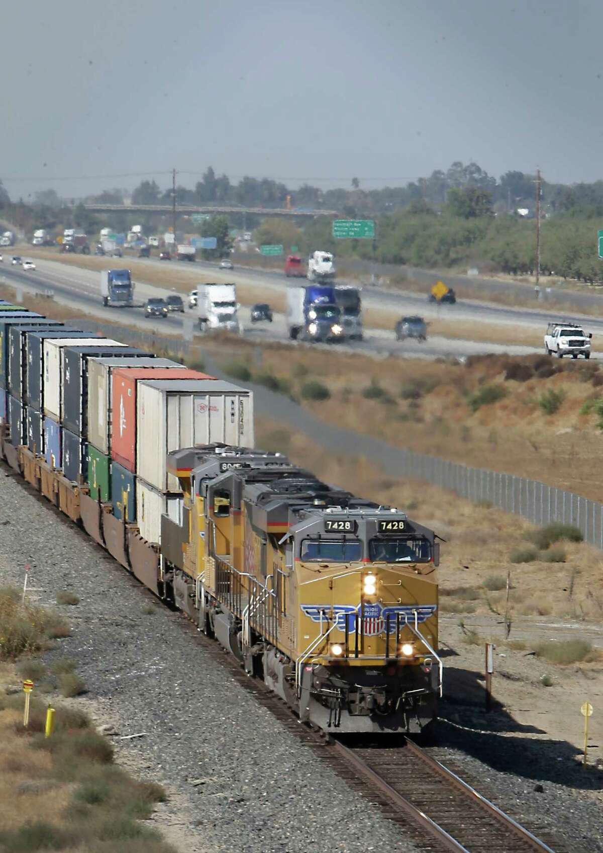 FILE - In this Thursday, Oct. 10, 2013, file photo, a freight train travels south alongside Highway 99 near Livingston, Calif. Freight railroads might be forced to allow rivals to serve some customers along their tracks under a new proposed rule, announced Wednesday, July 27, 2016. Federal regulators say that if shippers can show they don?’t have many shipping options and can meet certain conditions, they should be able to get bids from competing railroads to haul their products. Railroads say the rule is unneeded and would make shipments less efficient. (AP Photo/Rich Pedroncelli, File) ORG XMIT: NYBZ486