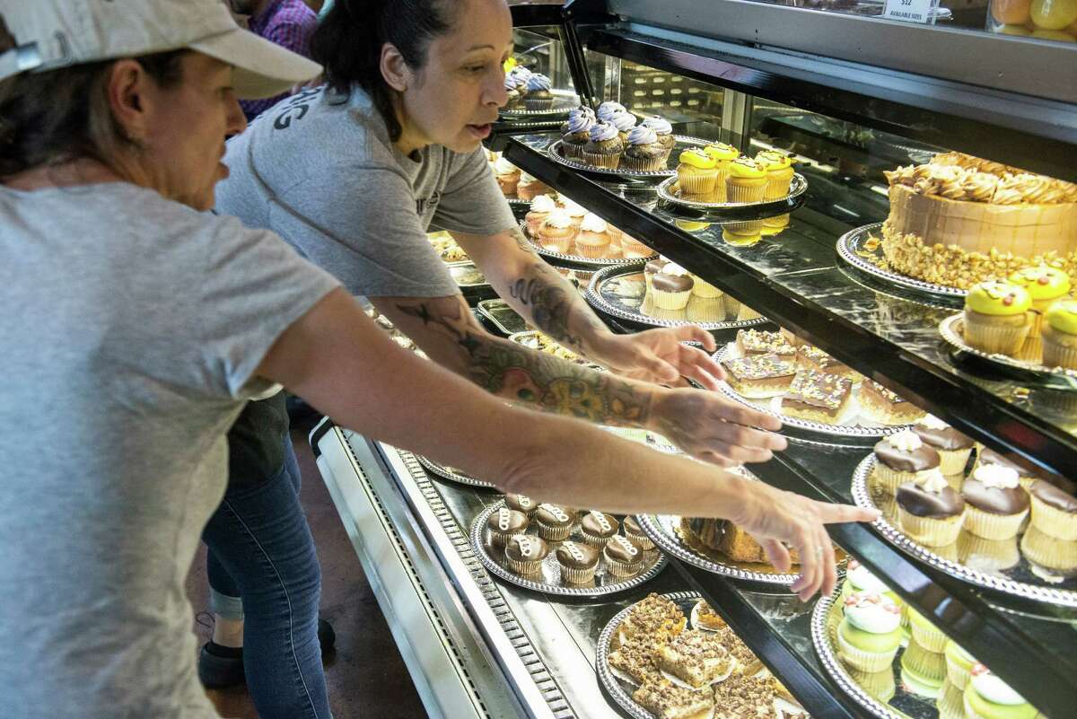 At Green Vegetarian Restaurant in The Pearl, waitress Ericka Rodulfo, center, helps Cindy Greenwood pick out a dozen vegan deserts for her friend's birthday.