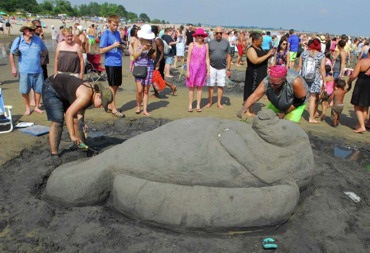 Beachgoers take part in the Milford Arts Council Annual Sand Sculpture Competition held at Walnut Beach in Milford on Saturday July 30. This event draws more than 50 sand sculptors and hundreds of spectators each year.