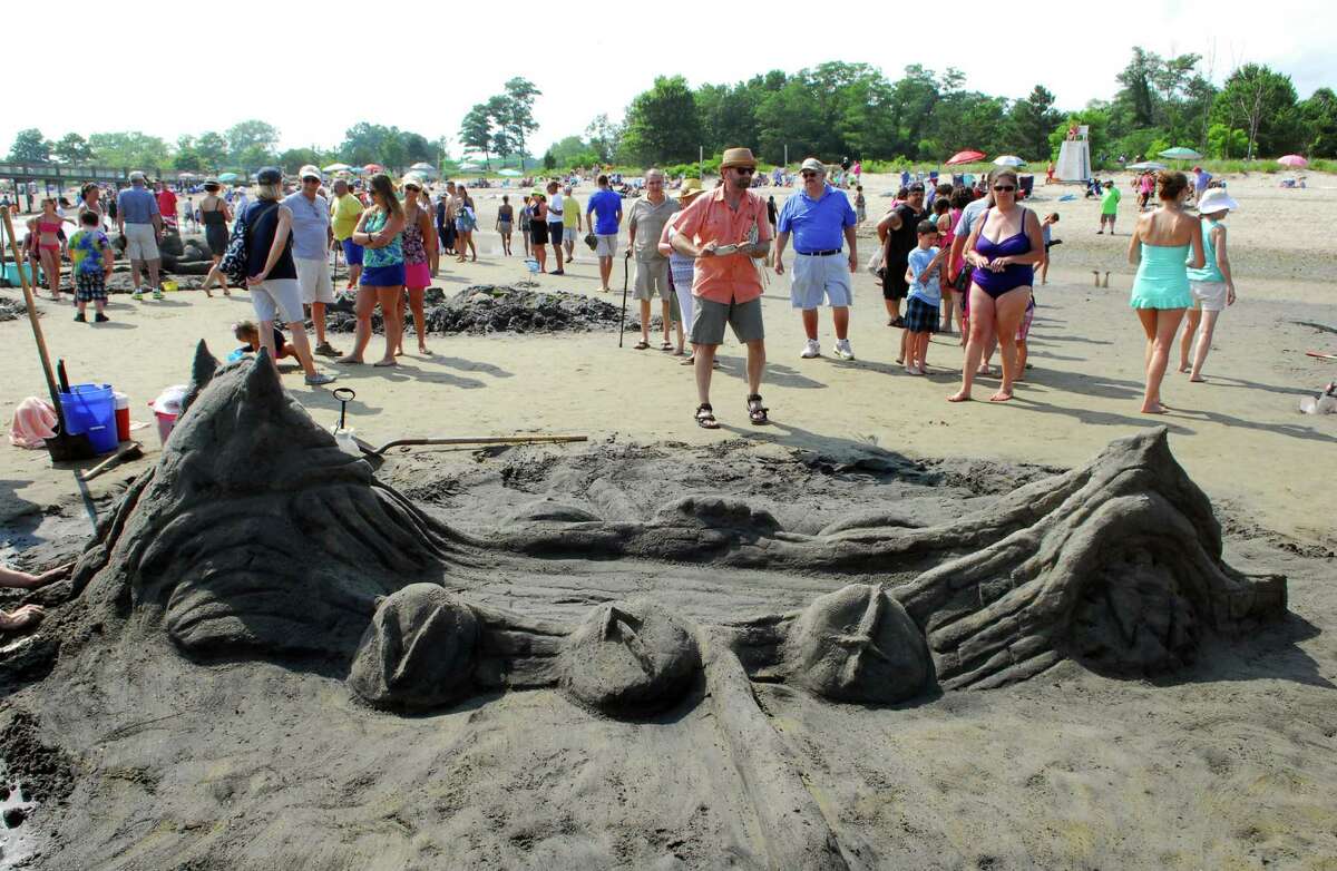 Beachgoers take part in the Milford Arts Council Annual Sand Sculpture Competition held at Walnut Beach in Milford on Saturday July 30. This event draws more than 50 sand sculptors and hundreds of spectators each year.