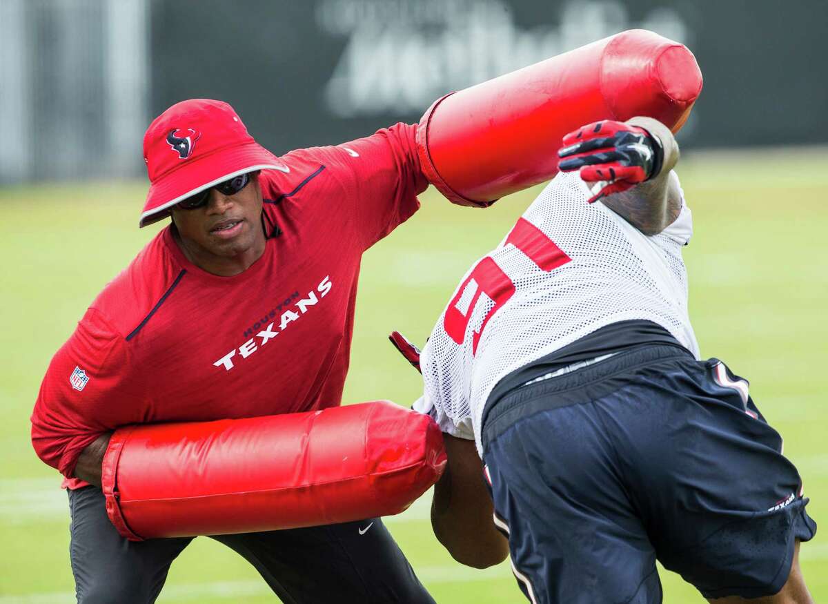 Houston Texans defensive line coach Anthony Weaver runs a drill with defensive tackle Devon Still (91) during Texans training camp at Houston Methodist Training Center on Sunday, July 31, 2016, in Houston.