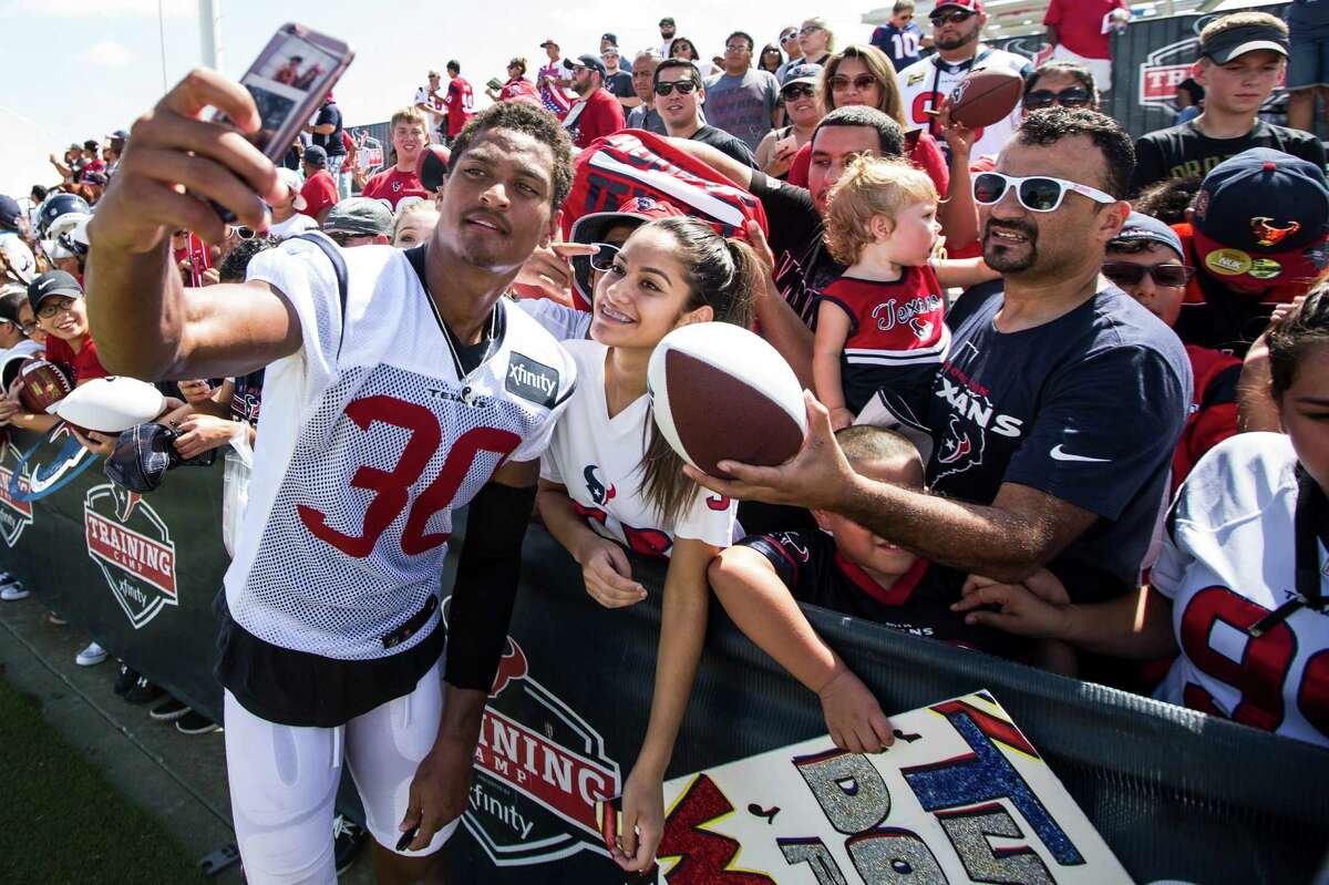 Houston Texans cornerback Kevin Johnson (30) takes a photo with a fan after practice during Texans training camp at Houston Methodist Training Center on Monday, Aug. 1, 2016, in Houston.
