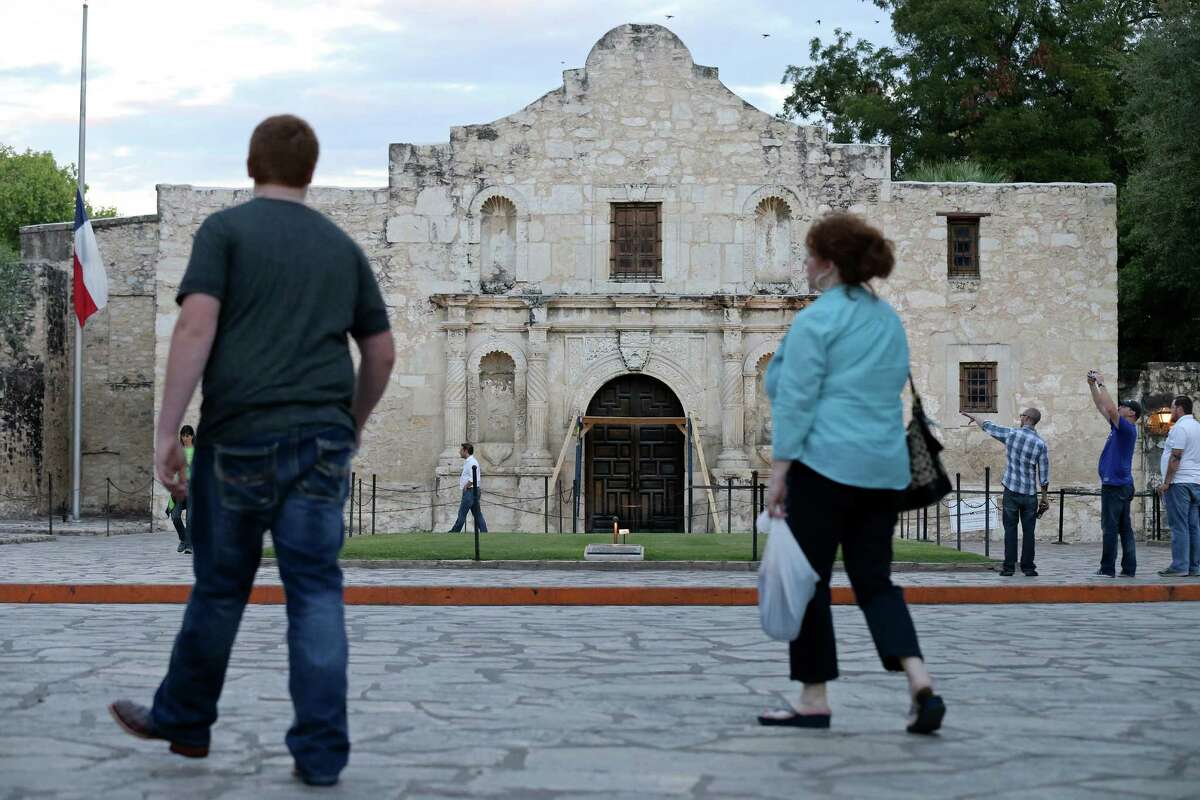 Pedestrians walk through Alamo Plaza, which the General Land Office oversees.