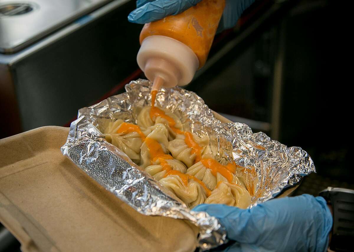 Spicy Tomato Cilantro sauce being put on the Turkey Momos at Bini's Kitchen in San Francisco, Calif., on December 23rd, 2015.