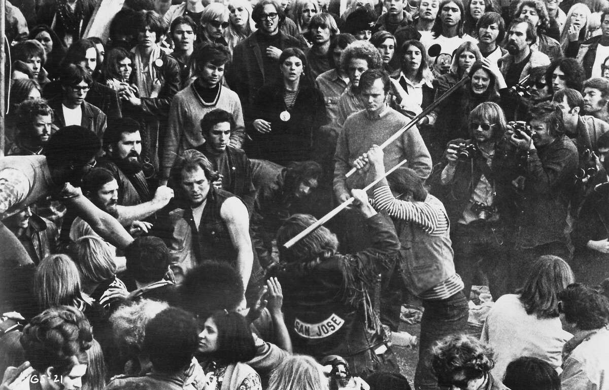 A still from the documentary film 'Gimme Shelter', showing audience members looking on as Hells Angels beat a fan with pool cues at the Altamont Free Concert, Altamont Speedway, California, 6th December 1969. The concert was headlined and organized by The Rolling Stones. The film was directed by Albert Maysles, David Maysles and Charlotte Zwerin. (Photo by 20th Century Fox/Michael Ochs Archives/Hulton Archive/Getty Images)