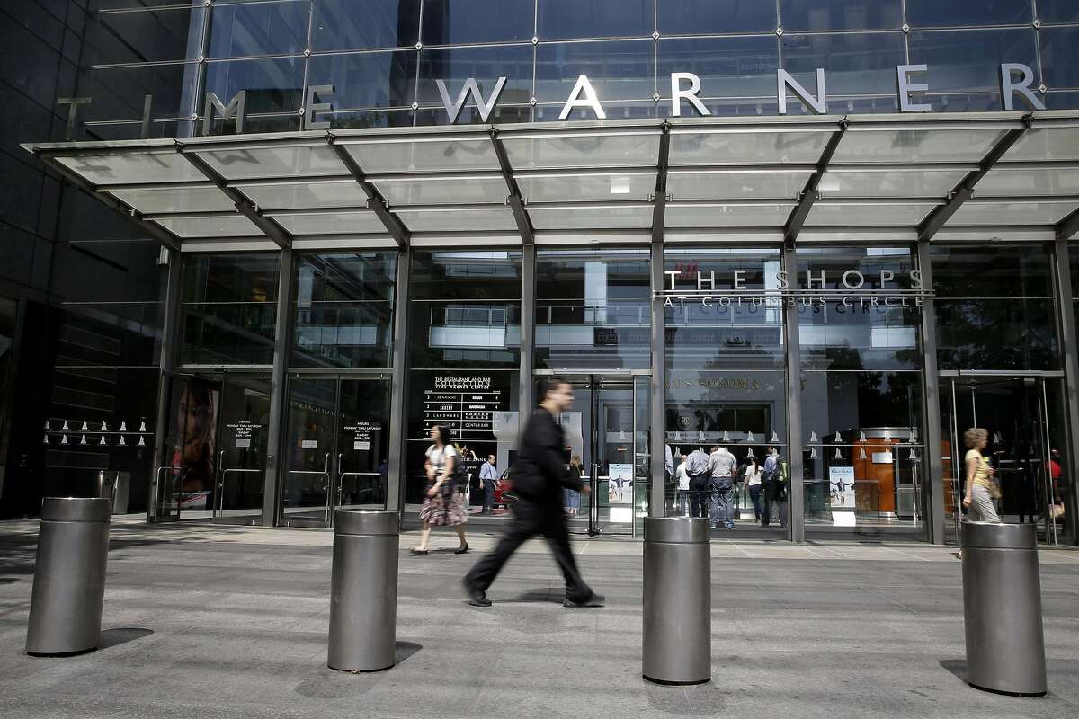 FILE - In this Tuesday, May 26, 2015, file photo, pedestrians walk past the Time Warner Center, home of the headquarters of Time Warner Cable, in New York. On Wednesday, Aug. 3, 2016, Time Warner Inc. reports financial results. (AP Photo/Mary Altaffer, File)
