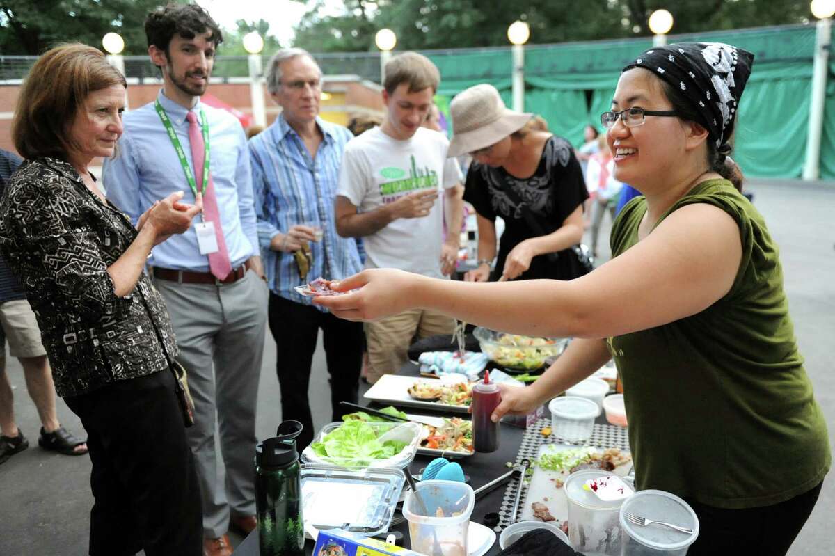 Angela Crupe of Rensselaer, right, hands out food samples to onlookers during the Grill Games final on Thursday, Aug. 20, 2015, at Saratoga Performing Arts Center in Saratoga Springs, N.Y. (Cindy Schultz / Times Union) ORG XMIT: MER2015082118211982