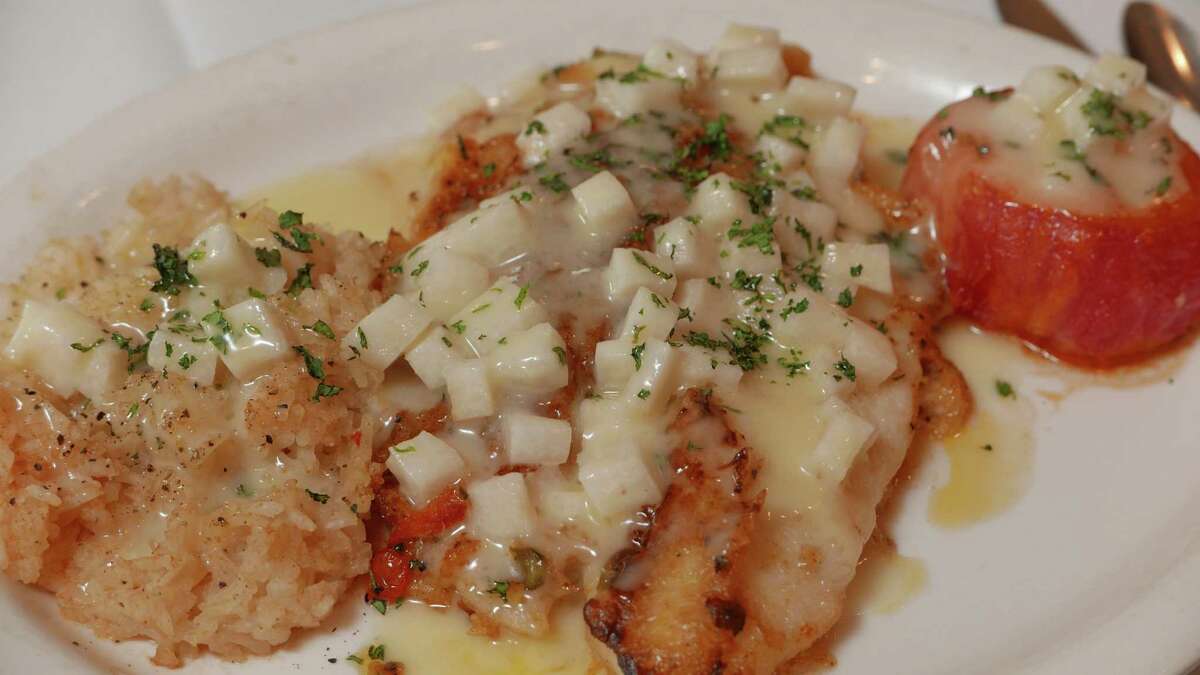 This red snapper with crabmeat is topped with a jicama butter sauce and served with a broiled tomato.