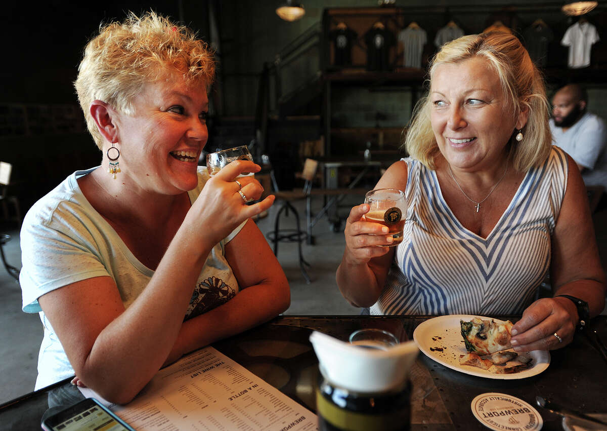 Brewport crossed county lines when it began serving New Haven-style pizza. Pictured: Friends Wendy Moran, left, and Marie Chaisson, both of Fairfield, enjoy a beer and some pizza during the first day of operation at the new Brewport Brewing Co. at 225 South Frontage Road in Bridgeport, Conn. on Monday, August 1, 2016.
