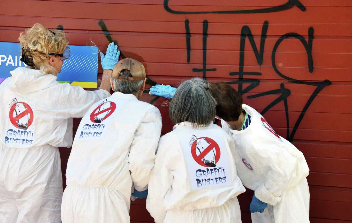 Graffiti Busters, volunteers from all four Troy neighbors work to remove graffiti from a garage door on Franklin Street Thursday Aug. 4, 2016 in Troy, NY. (John Carl D'Annibale / Times Union)