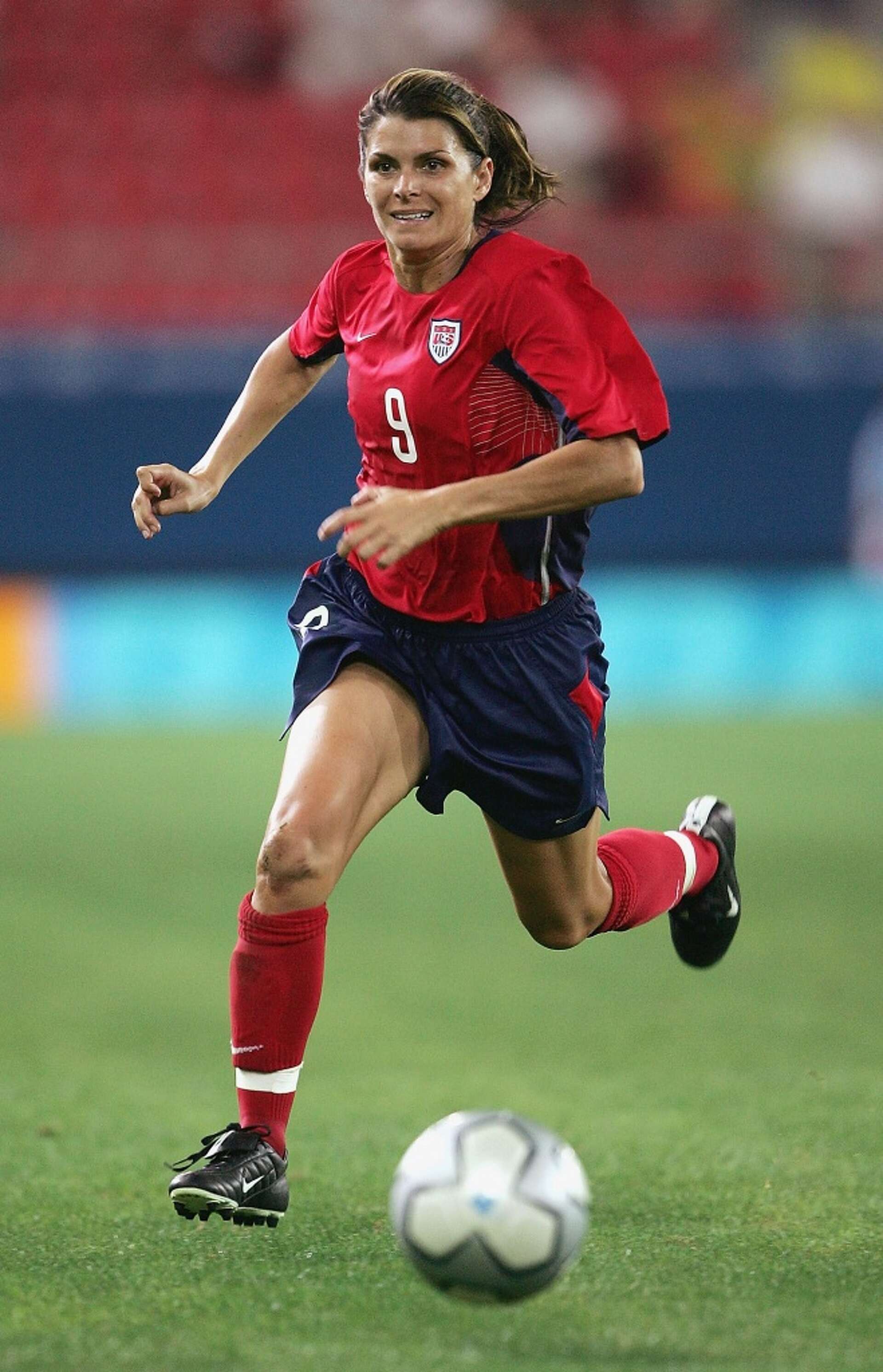 Mia Hamm sprinting on the soccer field in her USA jersey, showcasing elite skill and determination which makes Mia Hamm's soccer journey beginnings an outstanding story