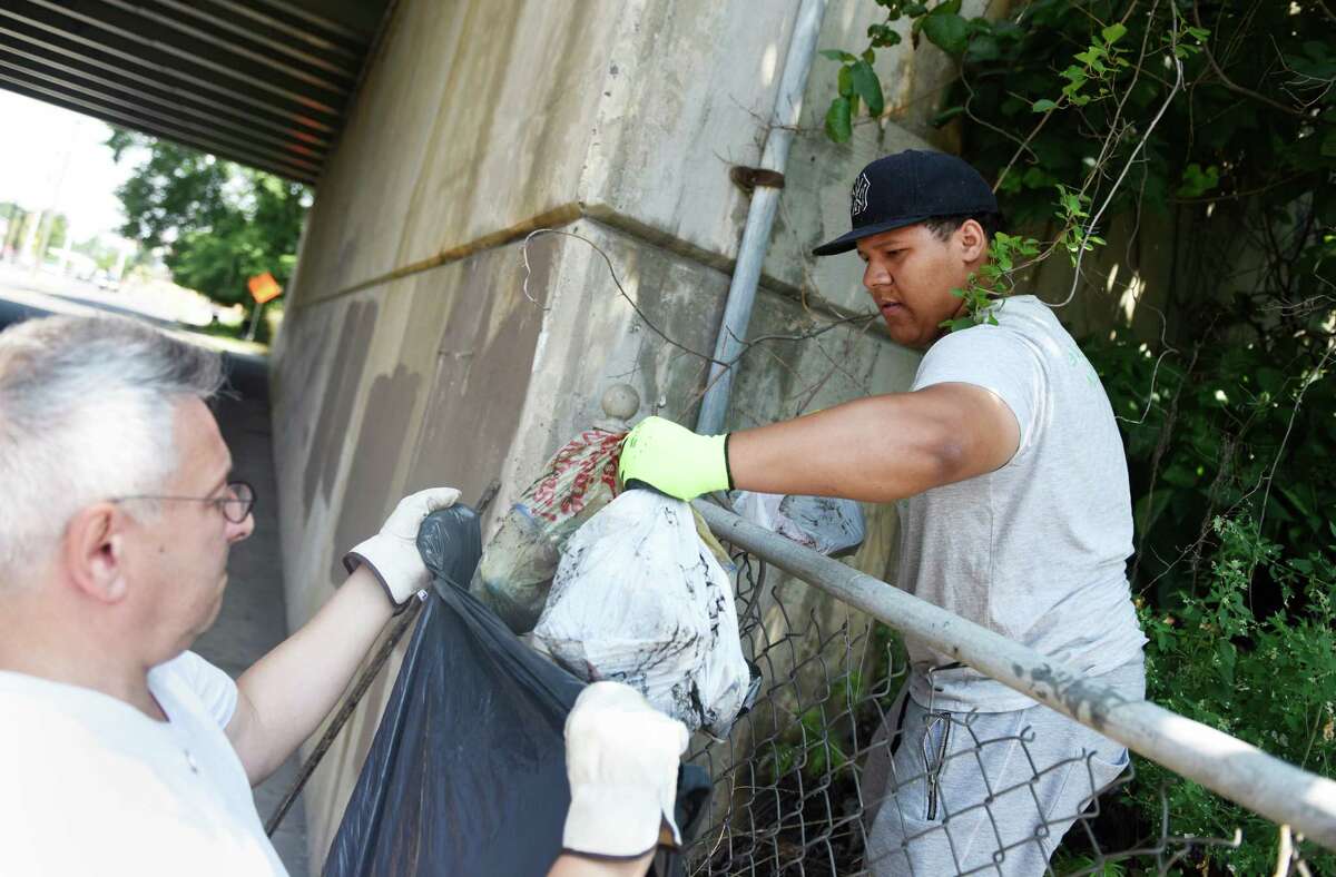 Future Five student Benedy Arias and Eastside Partnership Co-Founder and Chairman James Grunberger clean up trash from the side of the road on the east side of Stamford.