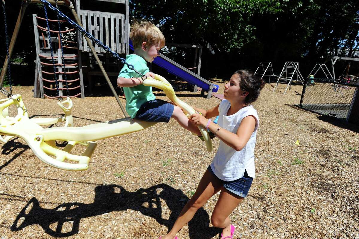 Counselor Danielle Decrescenzo pushes Thomas Leuzzi, 4, on a swing at Creative Care Preschool, on Washington Blvd. in downtown Stamford, on Wednesday, August 3, 2016.