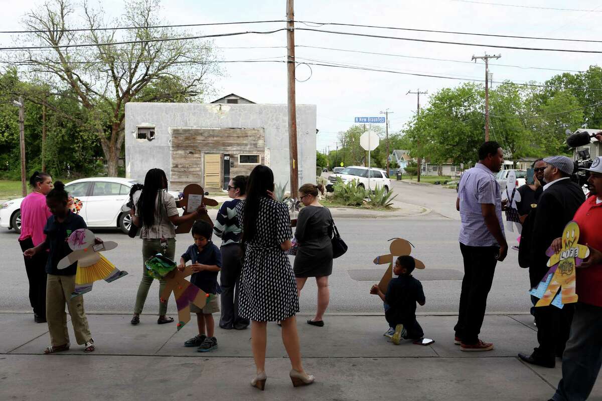 Participants hold cardboard kids as they stand along N. New Braunfels as traffic passes during the Cardboard Kids event with the Eastside Promise Neighborhood and Childsafe for a child abuse awareness campaign outside the Handy Stop Convenience Store on the eastern edge of Dignowity Hill on April 7, 2016.