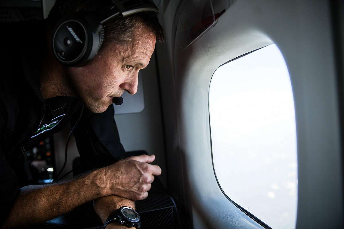 Scientist Greg Asner peers out a window during a flight to map tree health in the Sierras, July 27, 2016.
