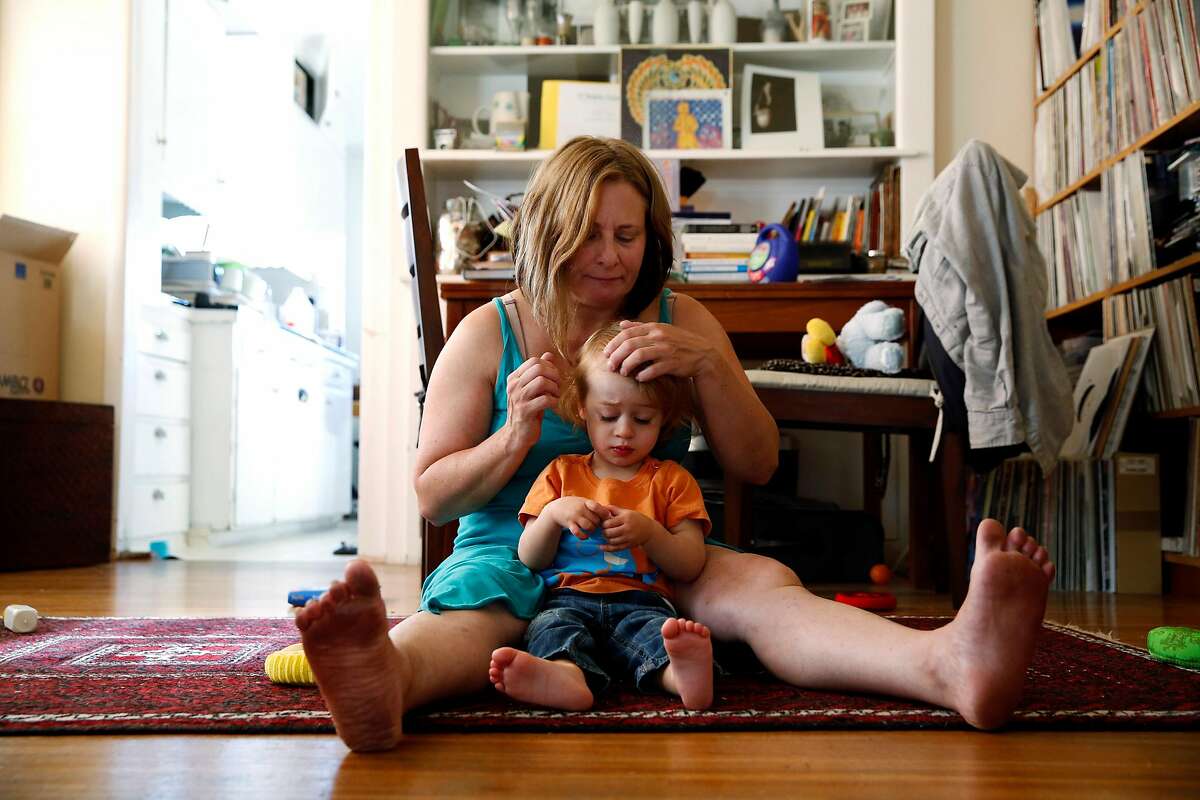 Alyson Kohn brushes aside her son Julian Black's hair at their home in Emeryville, California, on Monday, August 1, 2016.