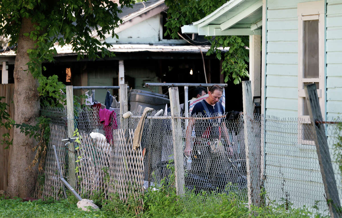A fire fighter looks through the yard of a house on Green Street where at least one person died in a fire August 5, 2016