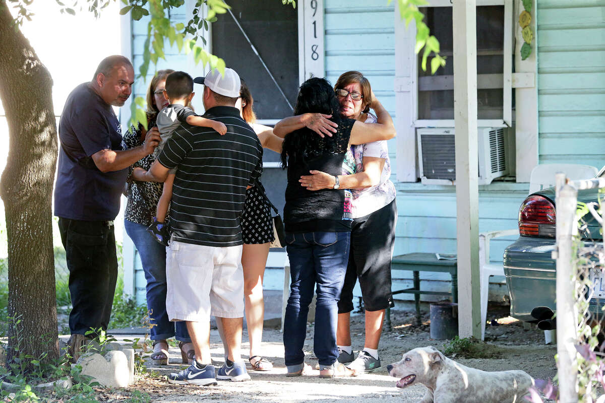 People console each other in the front of a house on 918 Green Street where at least one person died in a fire August 5, 2016