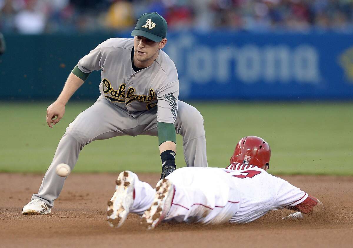 ANAHEIM, CA - AUGUST 2: Jed Lowrie #8 of the Oakland Athletics takes the throw from catcher Stephen Vogt #21 of the Oakland Athletics to throw out Mike Trout #27 of the Los Angeles Angels of Anaheim at second base during a steal attempt during the first inning of the baseball game at Los Angeles Angels of Anaheim at Angel Stadium of Anaheim August 2, 2016, in Anaheim, California. (Photo by Kevork Djansezian/Getty Images)