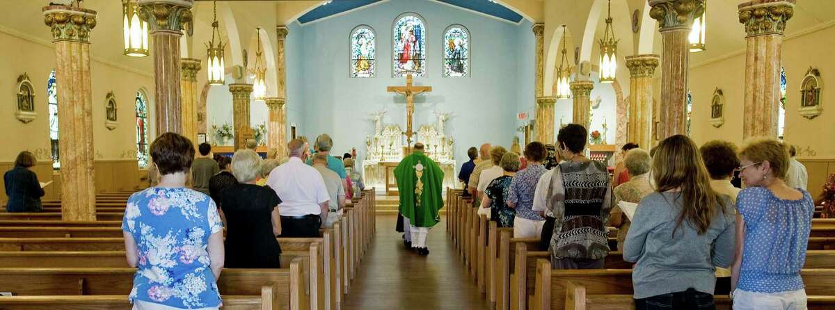 Father Peter Towsley walks down the aisle at Sacred Heart of Jesus Parish in Danbury at the beginning of the Saturday 5:00 pm Vigil mass. Saturday, July 23, 2016