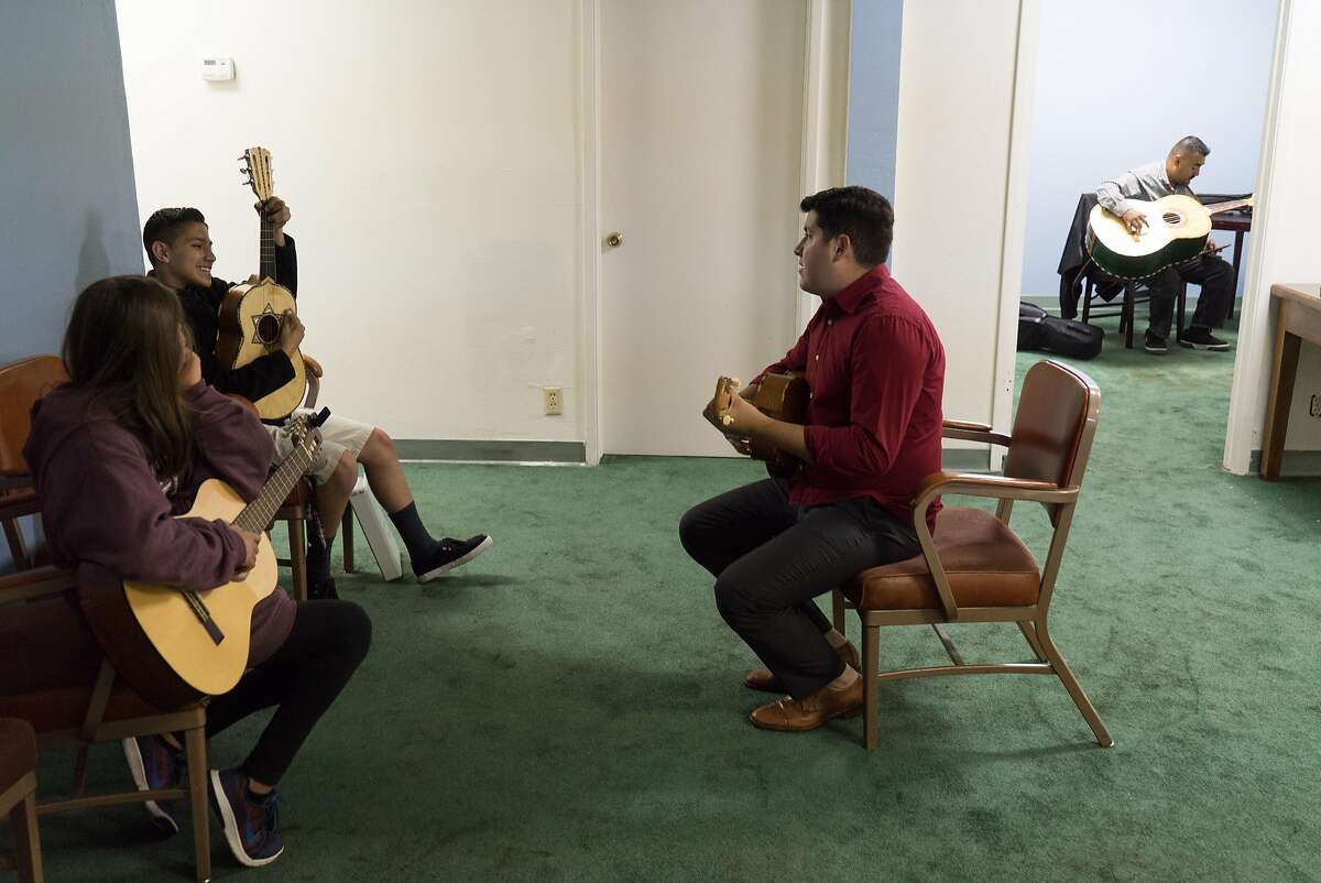 Rene Lambert, second from right, teaches students how to play the Vihuela at the Gilroy Historic Hotel in downtown Gilroy, Calif. on Saturday, Aug. 6, 2016. Felipe Garcia and Jorge Rodriguez learned Mariachi music as children, now they are passing on their knowledge to others through their Mariachi school.